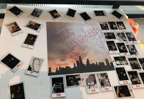 A themed display board titled 'Team Asian Hipsters' from a Polaroid scavenger hunt, featuring a central image of the Chicago skyline at sunset. The board is surrounded by numbered Polaroid photos capturing moments from the scavenger hunt challenges, arranged in a creative and organized layout. The display highlights teamwork and creativity during this engaging and fun-filled team building activity.