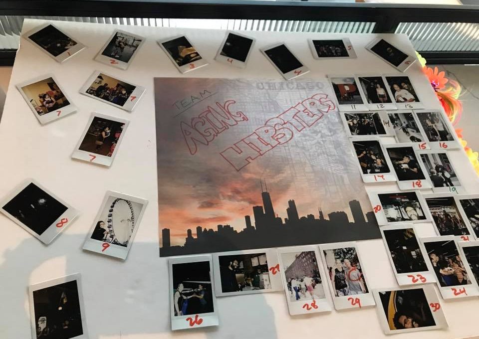 A themed display board titled 'Team Asian Hipsters' from a Polaroid scavenger hunt, featuring a central image of the Chicago skyline at sunset. The board is surrounded by numbered Polaroid photos capturing moments from the scavenger hunt challenges, arranged in a creative and organized layout. The display highlights teamwork and creativity during this engaging and fun-filled team building activity.