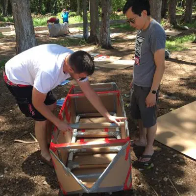 Two participants assembling the structure of a cardboard boat during the Build-A-Boat team building activity. thumbnail