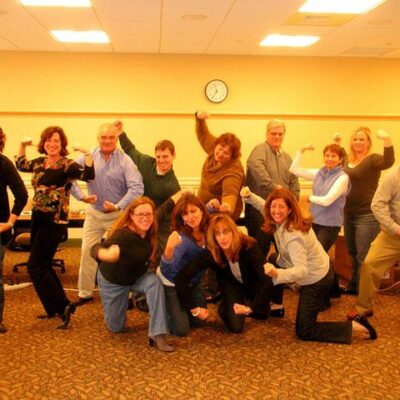 Employees posing in the camera with big smiles on the faces. thumbnail