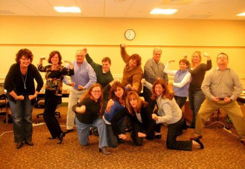 Employees posing in the camera with big smiles on the faces.