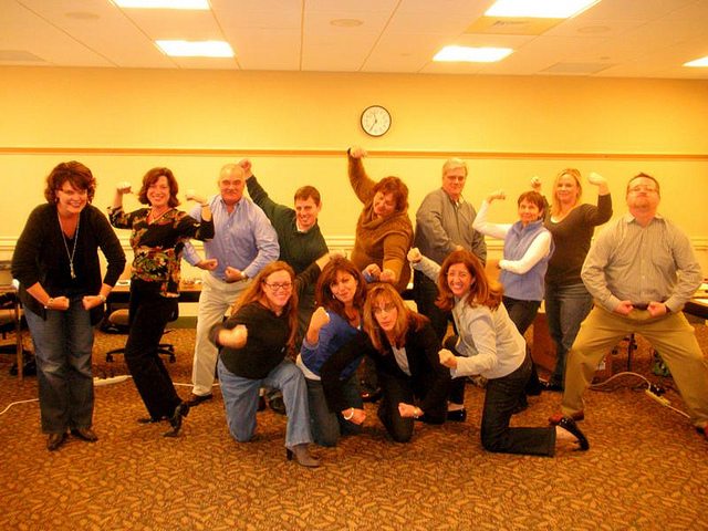 Employees posing in the camera with big smiles on the faces.