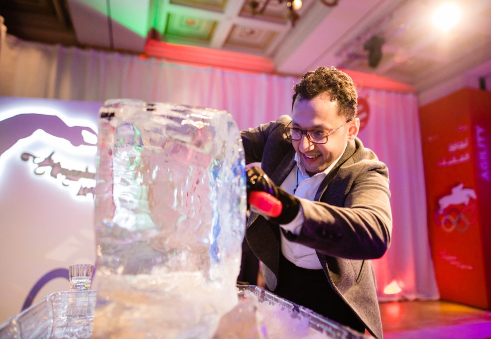 A participant skillfully chisels an ice block during an engaging Team building Ice Sculpting activity, focused on creativity and collaboration.