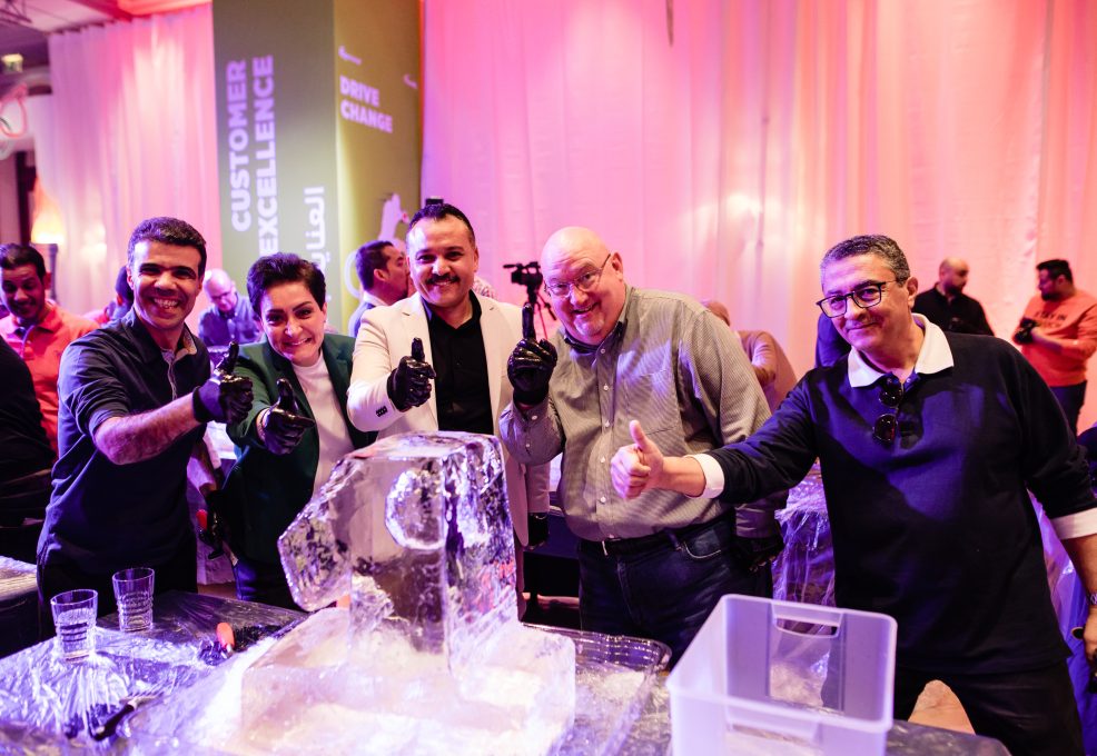A group of participants gives a thumbs up next to their ice sculpture, celebrating teamwork and creativity during an exciting Team building Ice Sculpting challenge.
