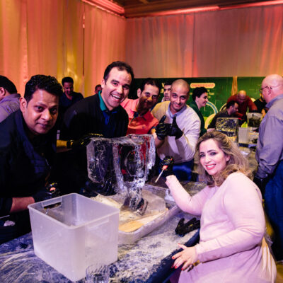 A team enthusiastically works together on their ice sculpting project during a Team building Ice Sculpting event, displaying their creativity and collaboration skills. thumbnail