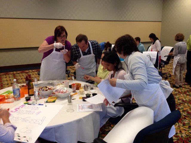 Employees and contestant check their recipe while the woman tasted