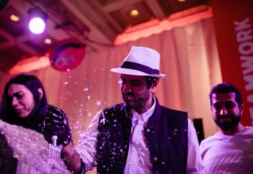 A team collaborates to create an ice sculpture at a Team building Ice Sculpting event, using tools to carefully shape the frozen block into a masterpiece.