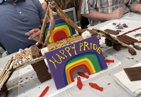 A colorful chocolate bridge constructed by a team during The Chocolate Challenge team building event. The bridge features a rainbow and a 