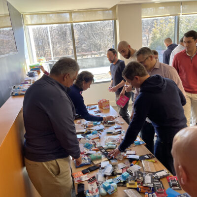 Team members enthusiastically sorting items to create care packages for military personnel during the Operation Military Care event. thumbnail