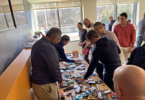Team members enthusiastically sorting items to create care packages for military personnel during the Operation Military Care event.