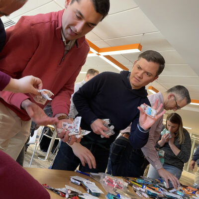 Employees working together to collect and pack items for military care packages during a team building event. thumbnail