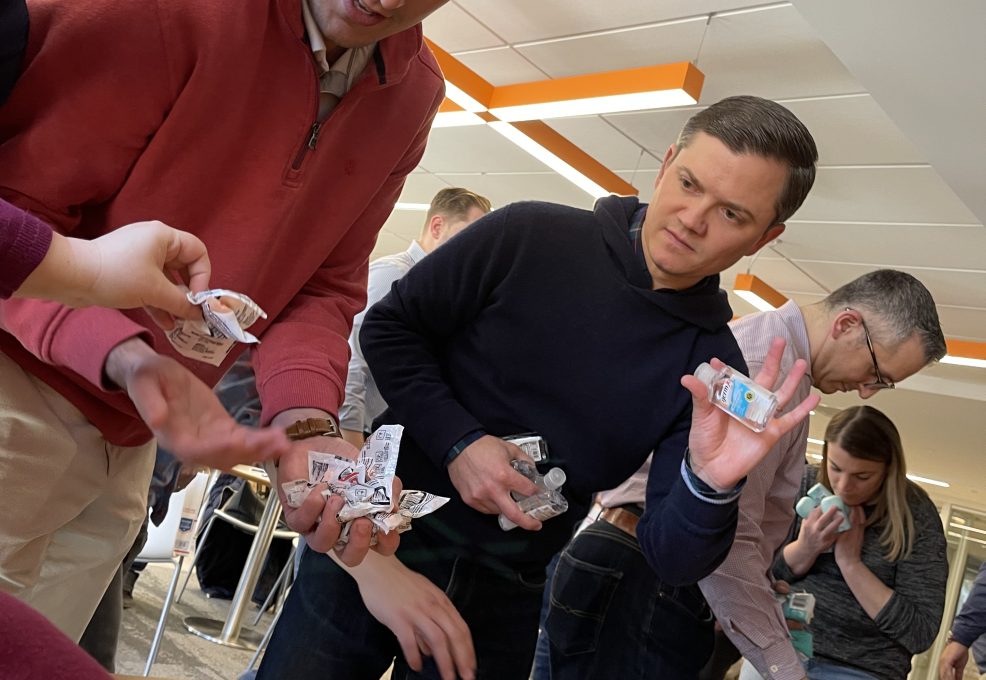 Employees working together to collect and pack items for military care packages during a team building event.