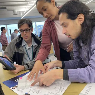 Team reviews case files and clues to solve the mystery during the Corporate CSI team building event. thumbnail