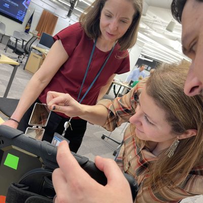Group of colleagues reviewing evidence and analyzing a tablet during the Corporate CSI team building event. thumbnail