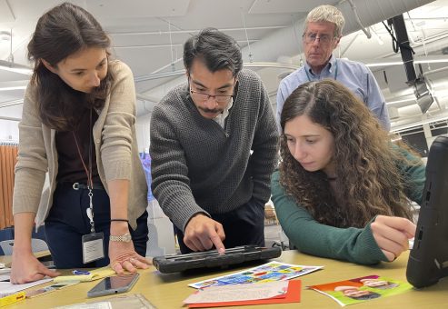 Participants collaborate while analyzing evidence on a tablet during the Corporate CSI team building event.