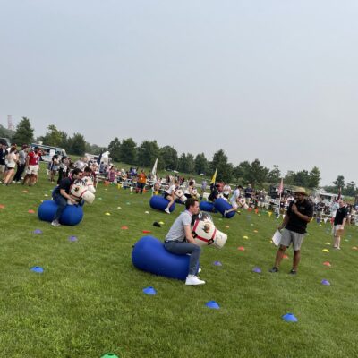 Participants competing in a relay race with inflatable horses during the Outrageous Games team building event. thumbnail