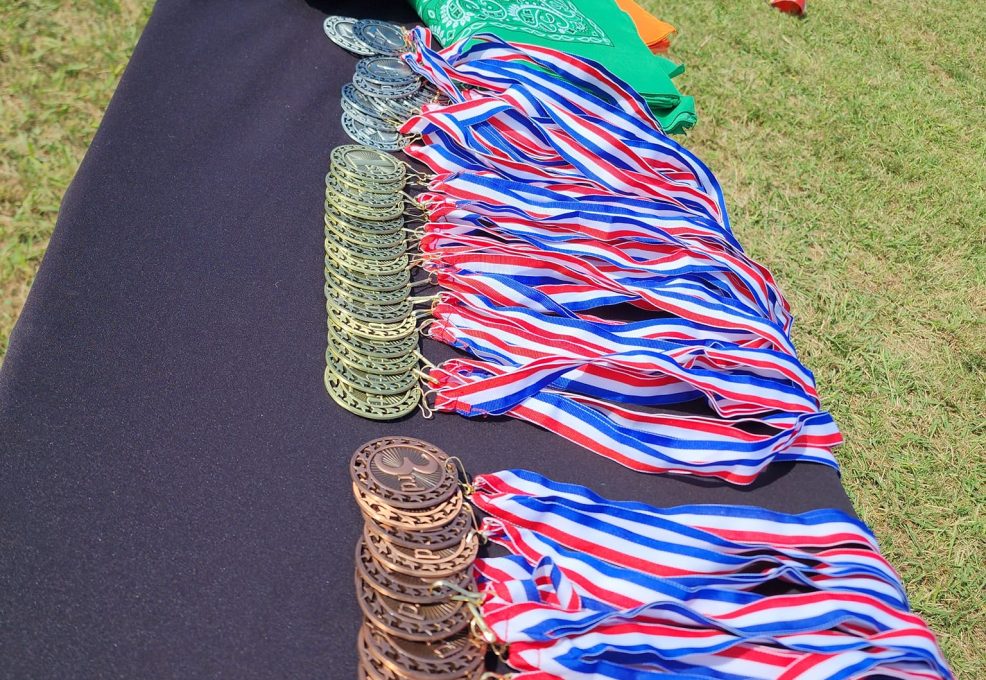 Medals and team flags displayed at an Outrageous Games team building event, ready for the award ceremony after a day of fun challenges.