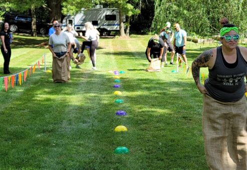 Participants racing in a classic sack race during the Outrageous Games team building event, enjoying friendly competition and teamwork.