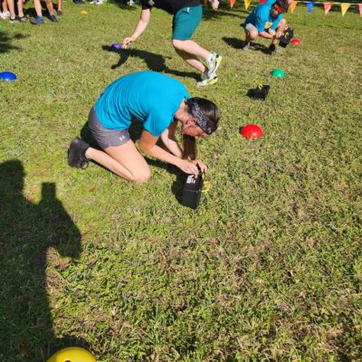 Participants work together to unlock a challenge during the Outrageous Games team building event, promoting teamwork and critical thinking. thumbnail