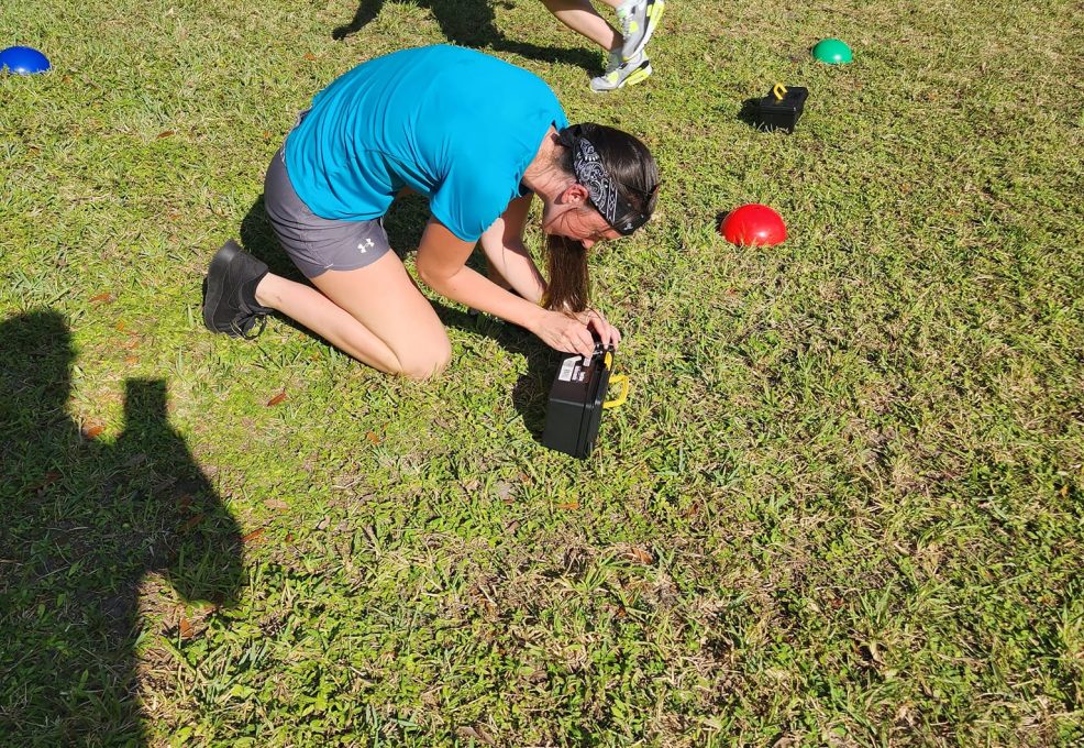 Participants work together to unlock a challenge during the Outrageous Games team building event, promoting teamwork and critical thinking.