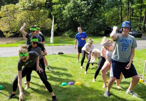 Teams competing in a relay race during the Outrageous Games team building event, fostering collaboration and fun.