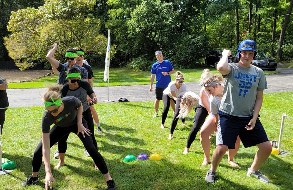 Teams competing in a relay race during the Outrageous Games team building event, fostering collaboration and fun.