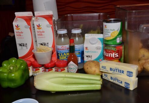 Fresh ingredients including milk, butter, celery, green pepper, and clam juice displayed for the Wicked Good Chowda Cook-Off team building event.