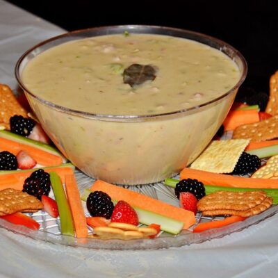Bowl of chowder surrounded by crackers, fresh vegetables, and berries at the Wicked Good Chowda Cook-Off team building event. thumbnail