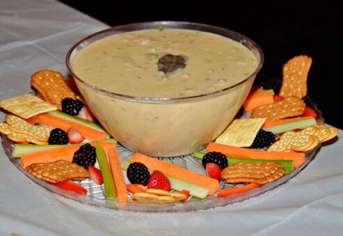 Bowl of chowder surrounded by crackers, fresh vegetables, and berries at the Wicked Good Chowda Cook-Off team building event.