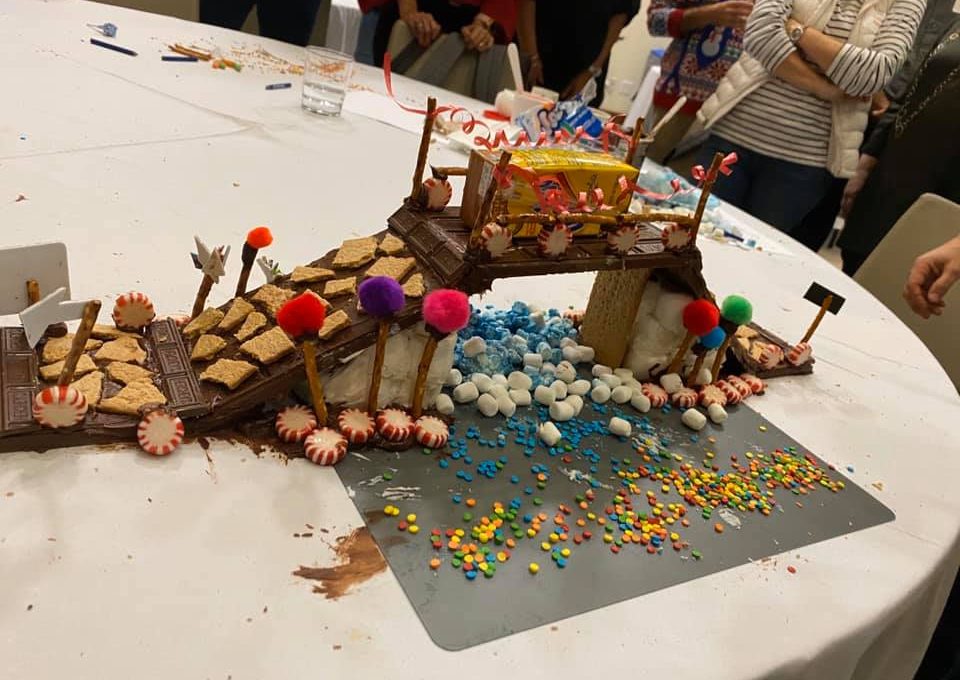 A detailed chocolate bridge created during The Chocolate Challenge team building event. The bridge is decorated with graham crackers, candy, and colorful sprinkles, showcasing creativity and teamwork.