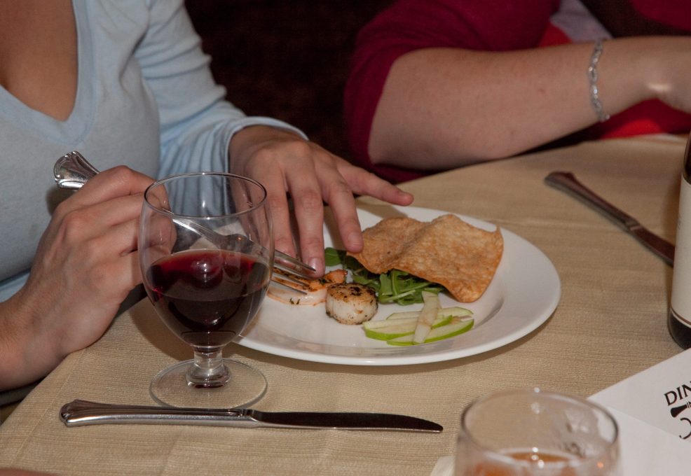 A participant enjoys a meal during a Dining in the Dark team building event, using sensory experiences to enhance connection and teamwork.