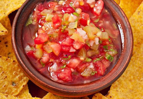 A vibrant bowl of fresh salsa surrounded by crispy tortilla chips, showcasing the flavors created during the Salsa Showdown team building event.