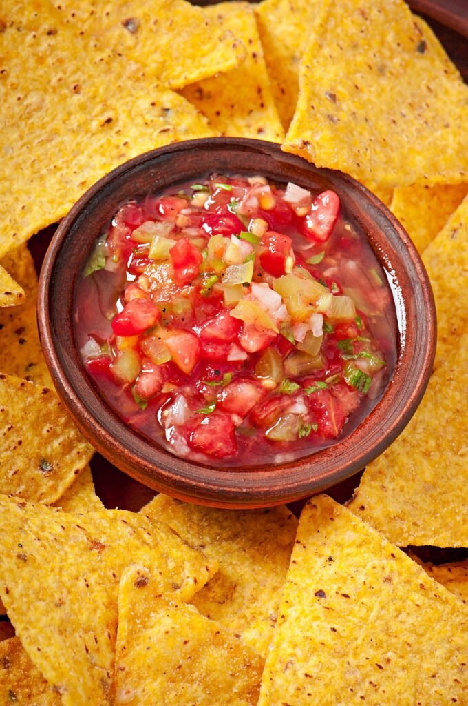 A vibrant bowl of fresh salsa surrounded by crispy tortilla chips, showcasing the flavors created during the Salsa Showdown team building event.
