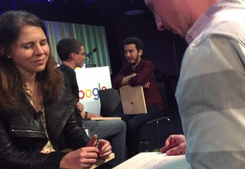 Participants engage in a reflective discussion during a board-breaking team building session, preparing to break through personal barriers.