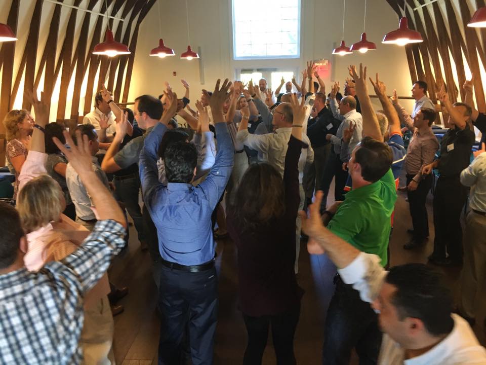 Employees raising their hands with four signs