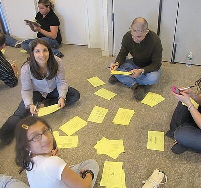 Team members collaborate on problem-solving challenges during a Big Give team building event, preparing for the charity-focused activities ahead. thumbnail