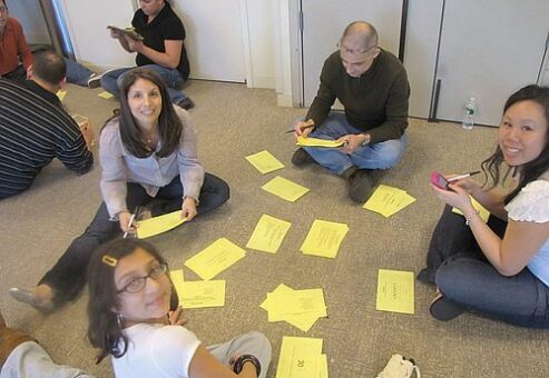 Team members collaborate on problem-solving challenges during a Big Give team building event, preparing for the charity-focused activities ahead.