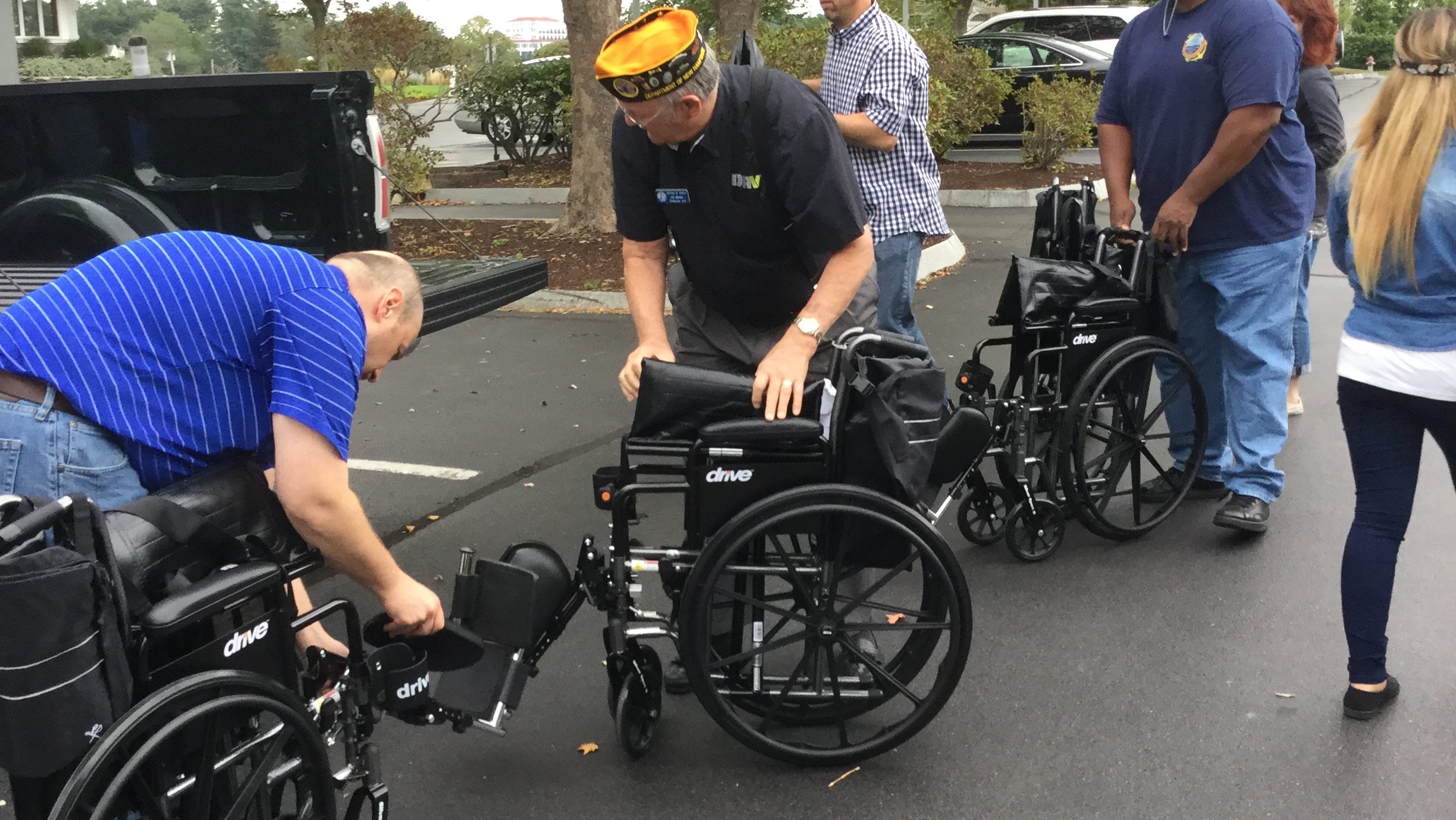 Employees giving a wheelchair to PWD