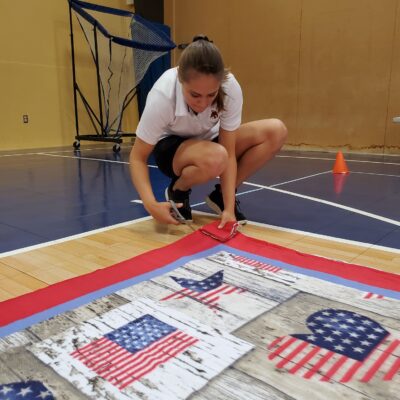 Team member diligently cuts fabric to assemble a fleece blanket during The Big Give charity team building event. thumbnail