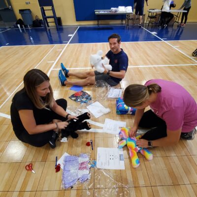 Team members assemble stuffed animals as part of The Big Give charity team building event, preparing toys for donation to children in need. thumbnail