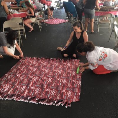 Participants at the Paws For A Cause team building event collaborate on creating colorful pull toys and cat scratch pads, crafting donations for local animal shelters to support animals in need. thumbnail