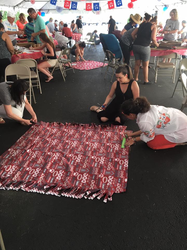 Participants at the Paws For A Cause team building event collaborate on creating colorful pull toys and cat scratch pads, crafting donations for local animal shelters to support animals in need.