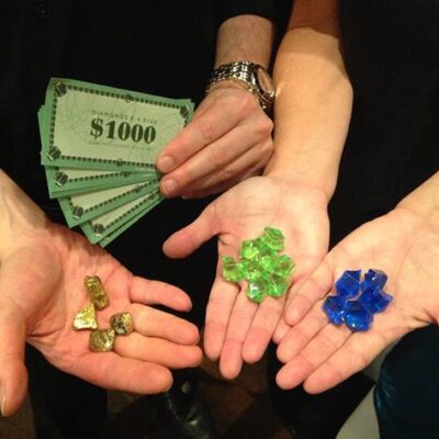 Four people, hands showing play cash, gold, green and blue rocks. thumbnail