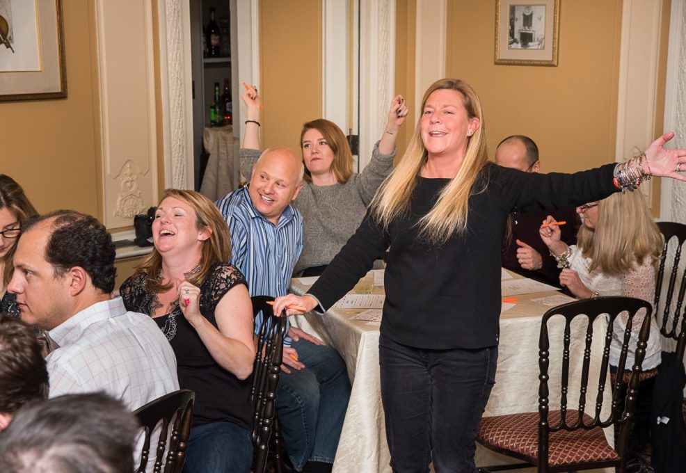 Participants celebrating and enjoying the Wild Card Team Building Bingo event with laughter and enthusiasm.