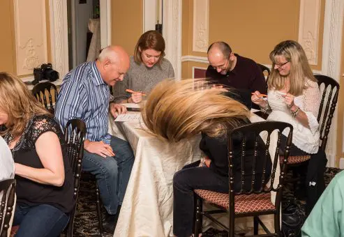 Engaged participants marking their bingo cards during the Wild Card Team Building Bingo event.