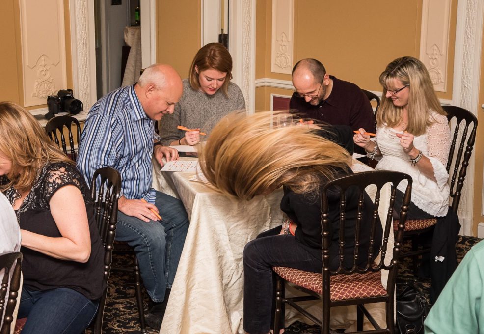 Engaged participants marking their bingo cards during the Wild Card Team Building Bingo event.