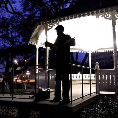 Man standing in a park at dusk.