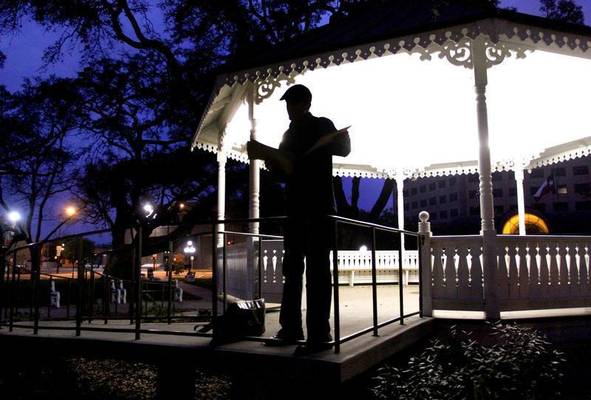 Man standing in a park at dusk.