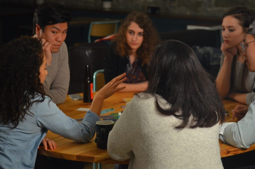 An employee share her thought as other attentively listen