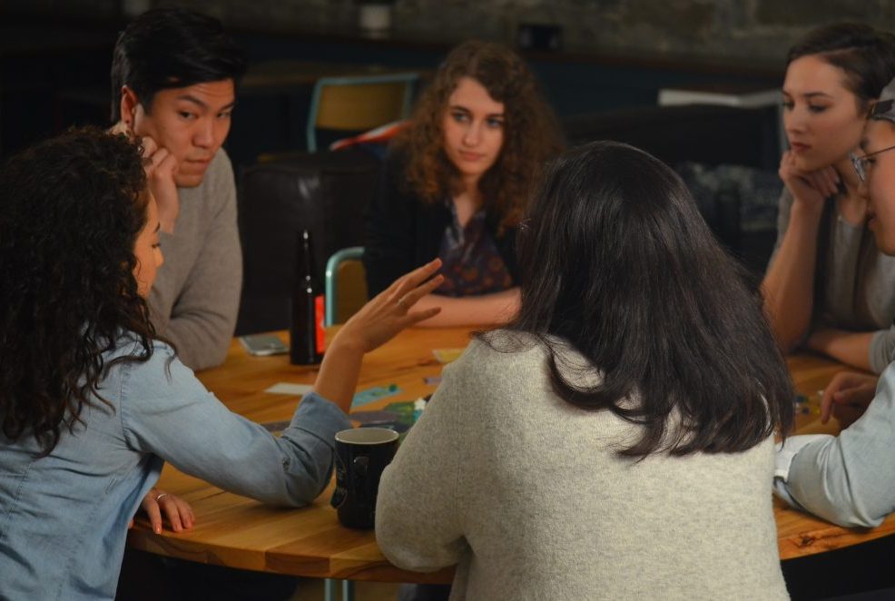 An employee share her thought as other attentively listen